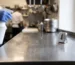 Blat de inox dintr-o bucătărie profesională acoperit cu soluție dezinfectantă, pe durata timpului de contact